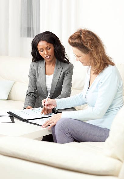 Senior woman meeting with financial advisor at home, signing document. Senior woman meeting with financial advisor at home, signing document.